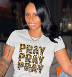 Woman wearing a gray t-shirt with 'PRAY or PRAY through it' text design.