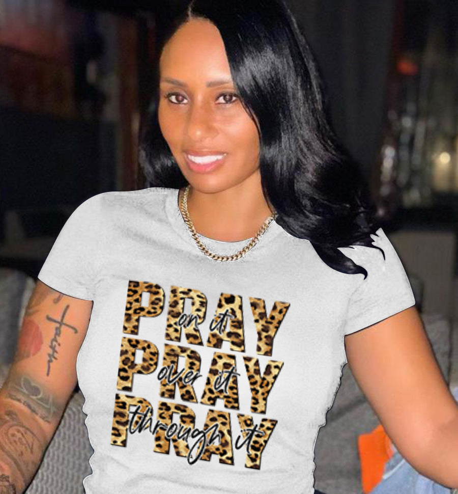 Woman wearing a gray t-shirt with 'PRAY or PRAY through it' text design.