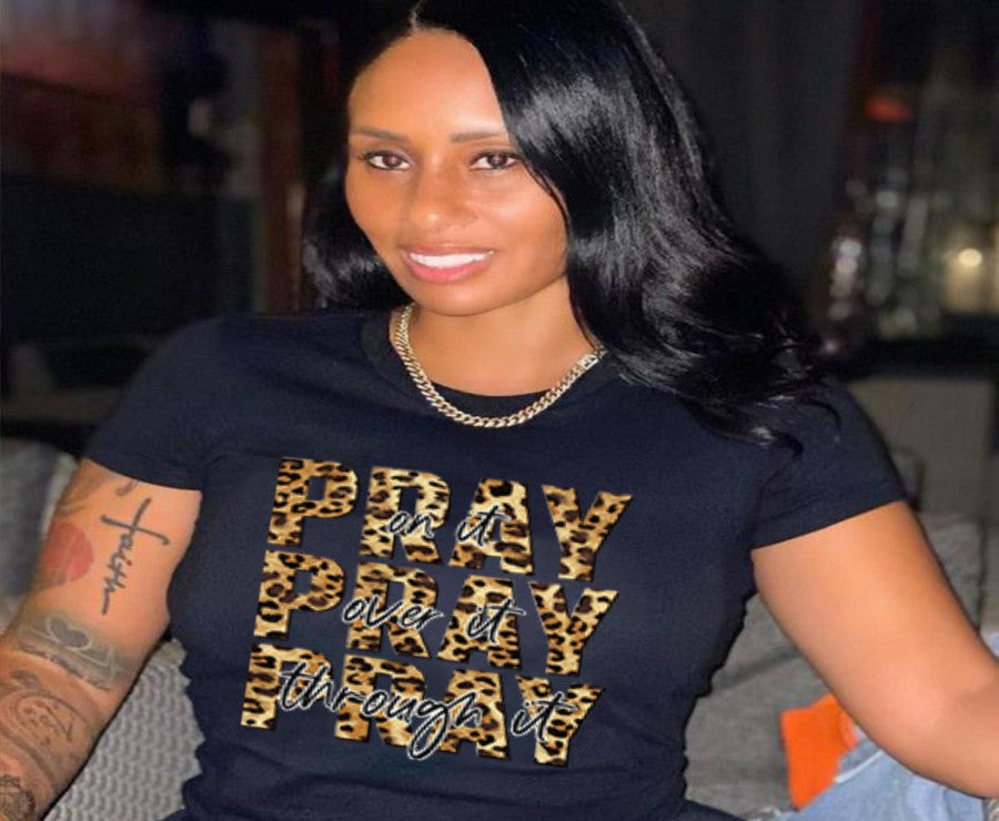 Woman wearing a black t-shirt with leopard print text in a casual setting