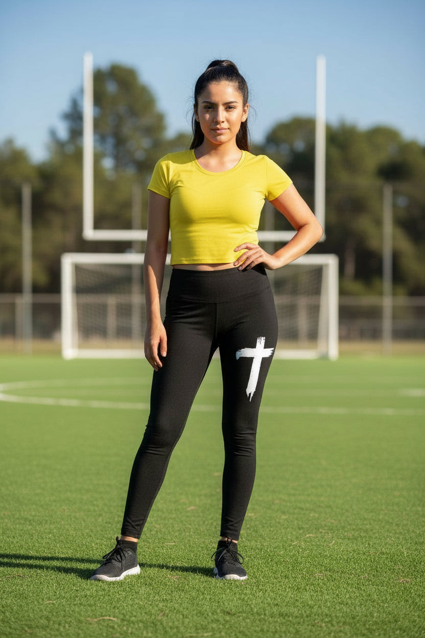Black leggings with a white cross design worn by a person, on a neutral background.